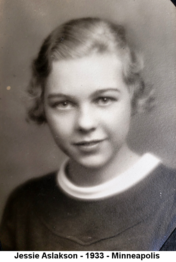 Black and white studio portrait photo of Jessie Aslakson, a young girl with short curled hair wearing a dark top with white shallow scoop-neck collar.